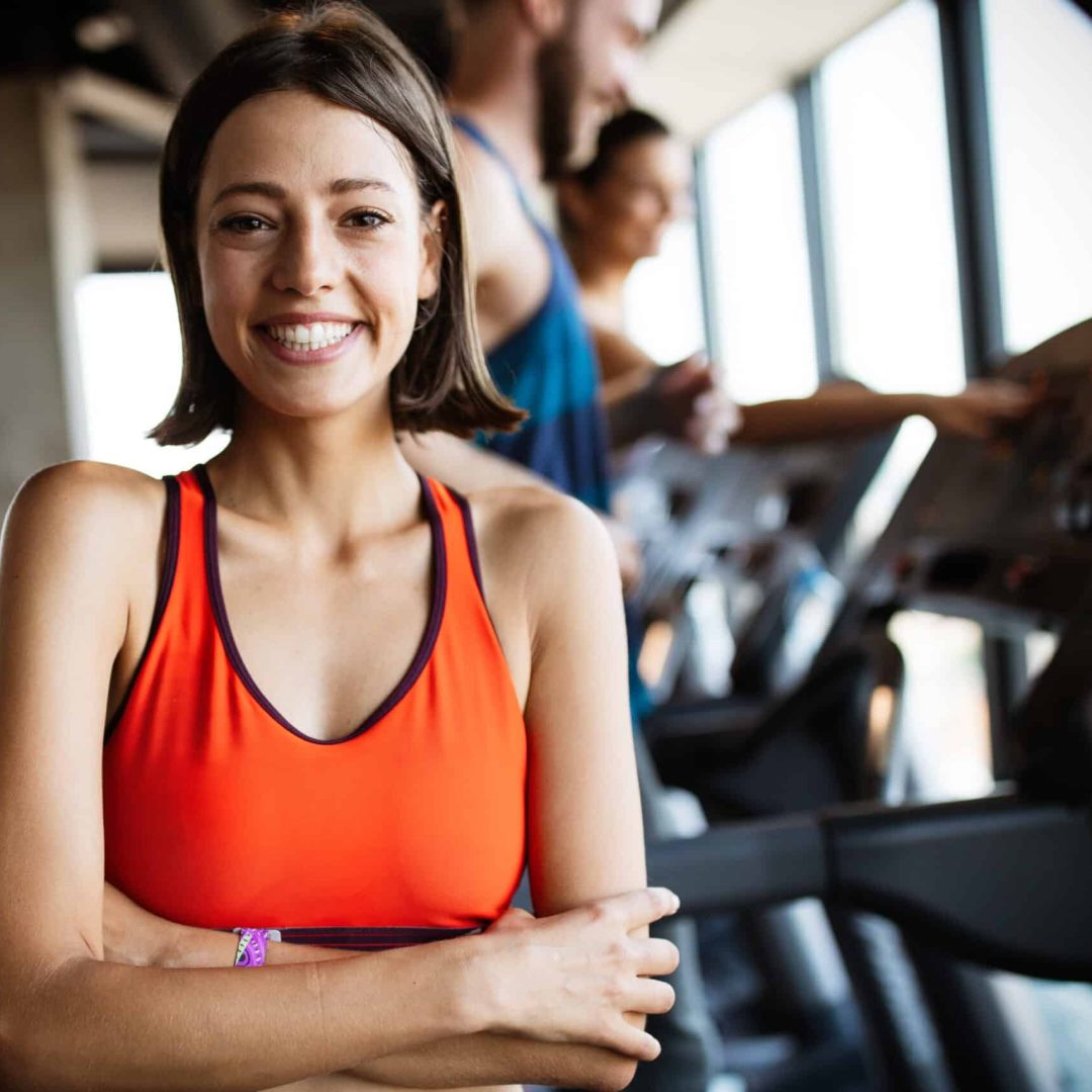 Close up image of attractive fit woman exercising in gym