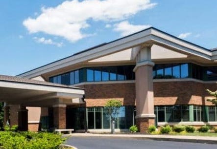 the front of a large building with lots of windows.