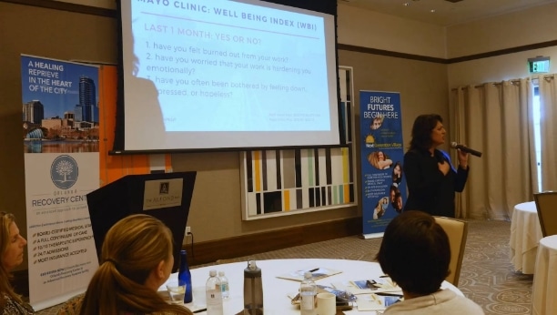 a woman giving a presentation to a group of people.