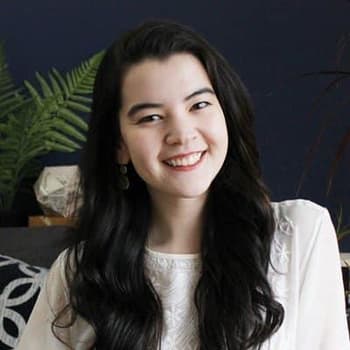 a woman sitting on a couch smiling at the camera.