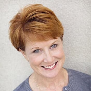 a woman with red hair smiling at the camera.