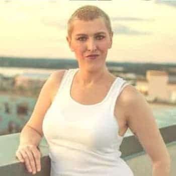 a woman in a white tank top posing for a picture.