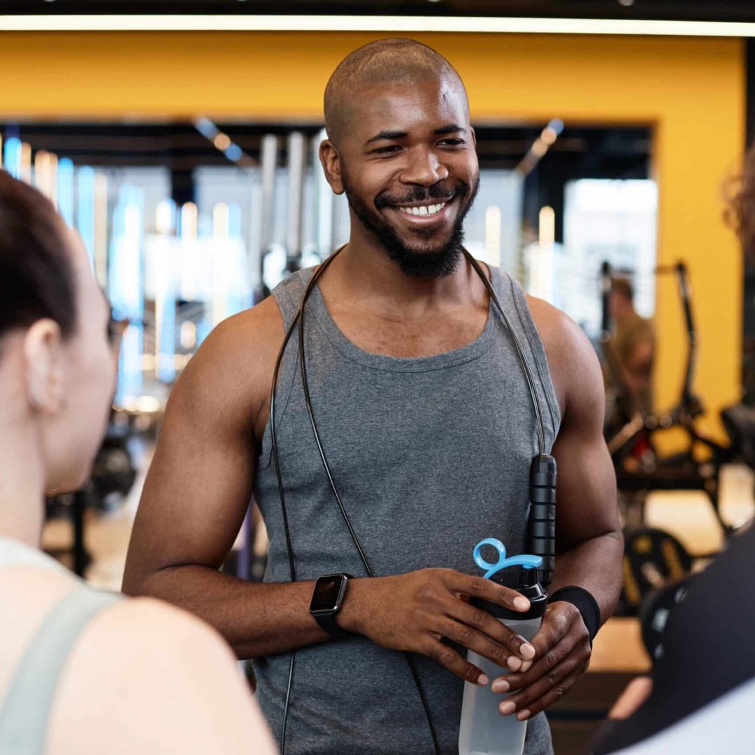 muscular-black-man-smiling-with-friends-in-gym-2024-05-20-17-12-20-utc-min