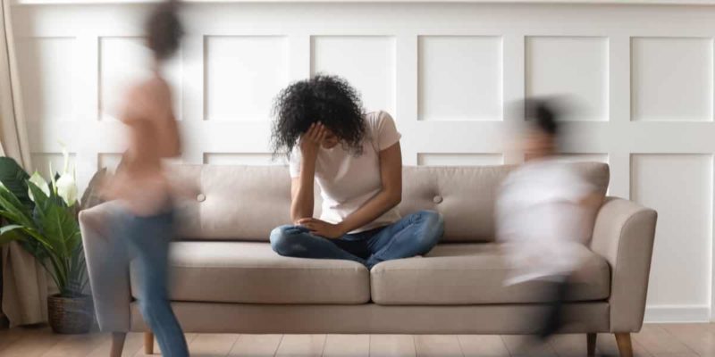 a woman sitting on top of a couch next to a man.