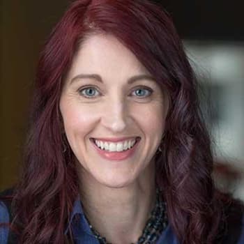 a woman with red hair smiling for a picture.