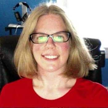 a woman wearing glasses sitting in a chair.