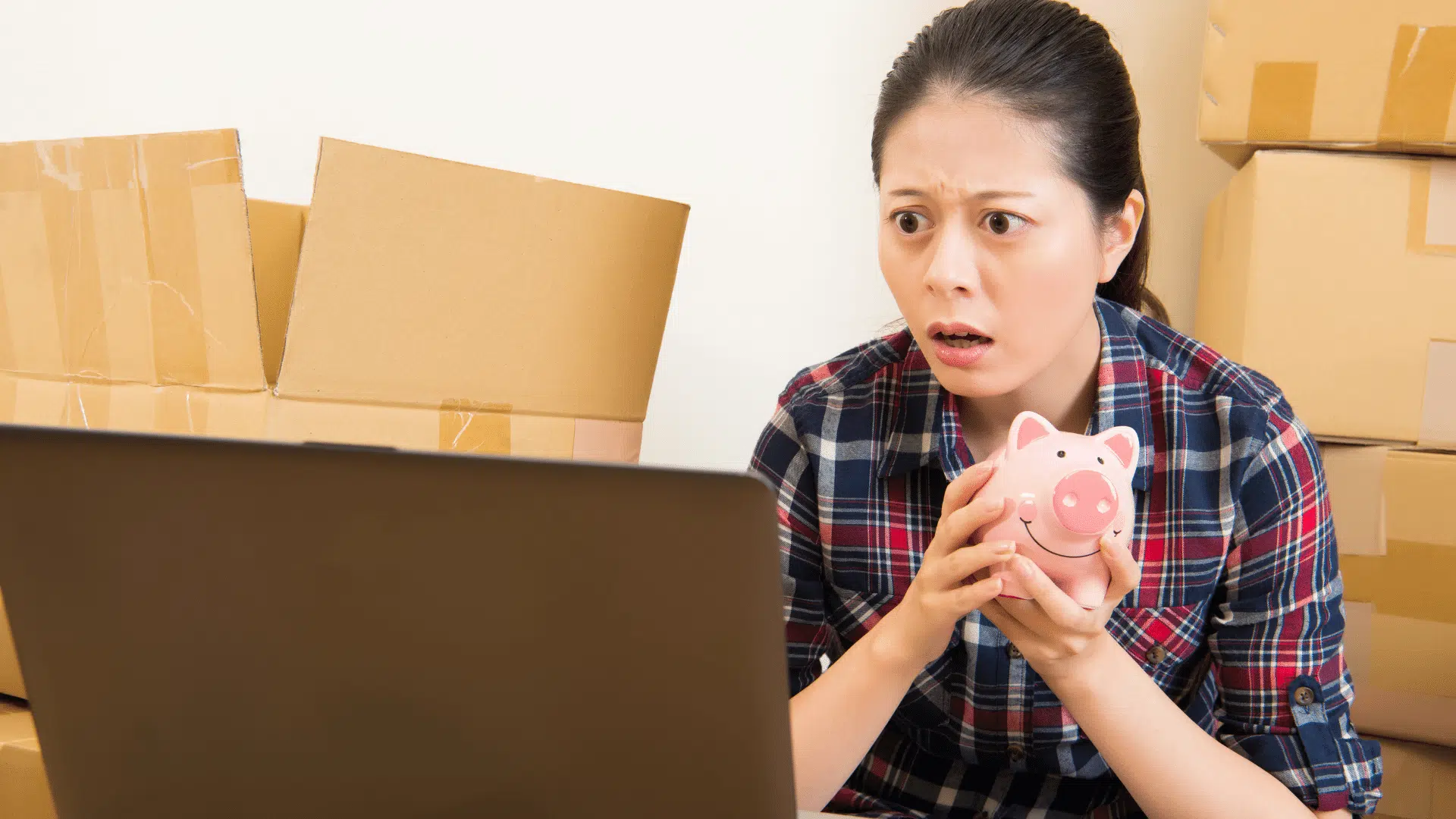 Woman clutching piggy bank in shock